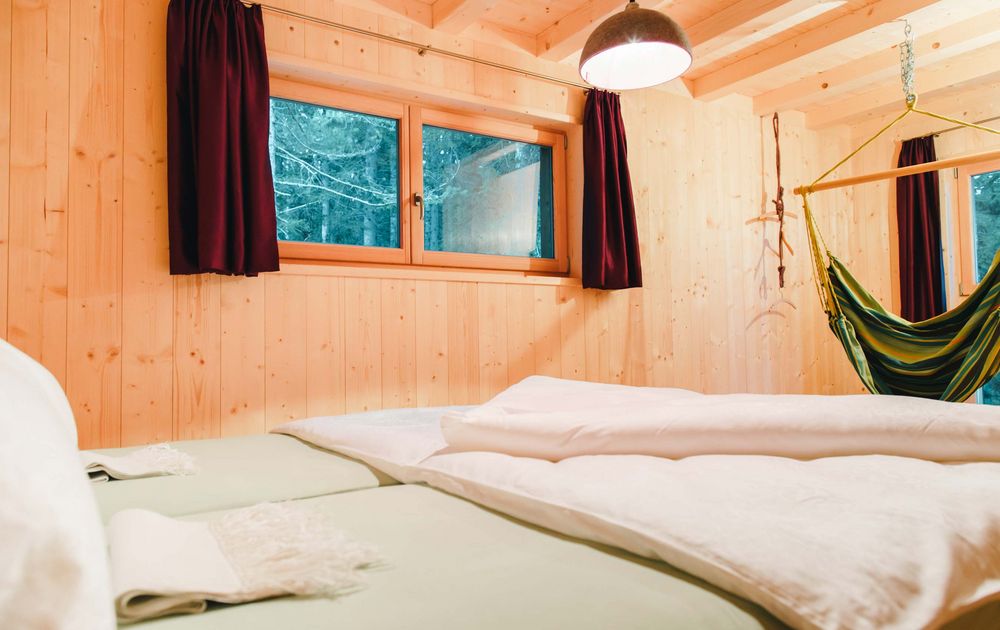 Schlafzimmer Hängematte Fenster Wald Chalet MOMO Natur Urlaub Südtirol