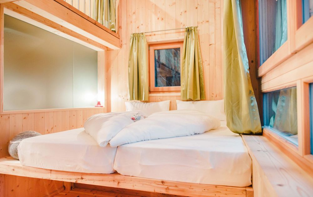 Zimmer mit Doppelbett im Chalet KAROM | feliZitas Forest Chalet Resort St. Felix