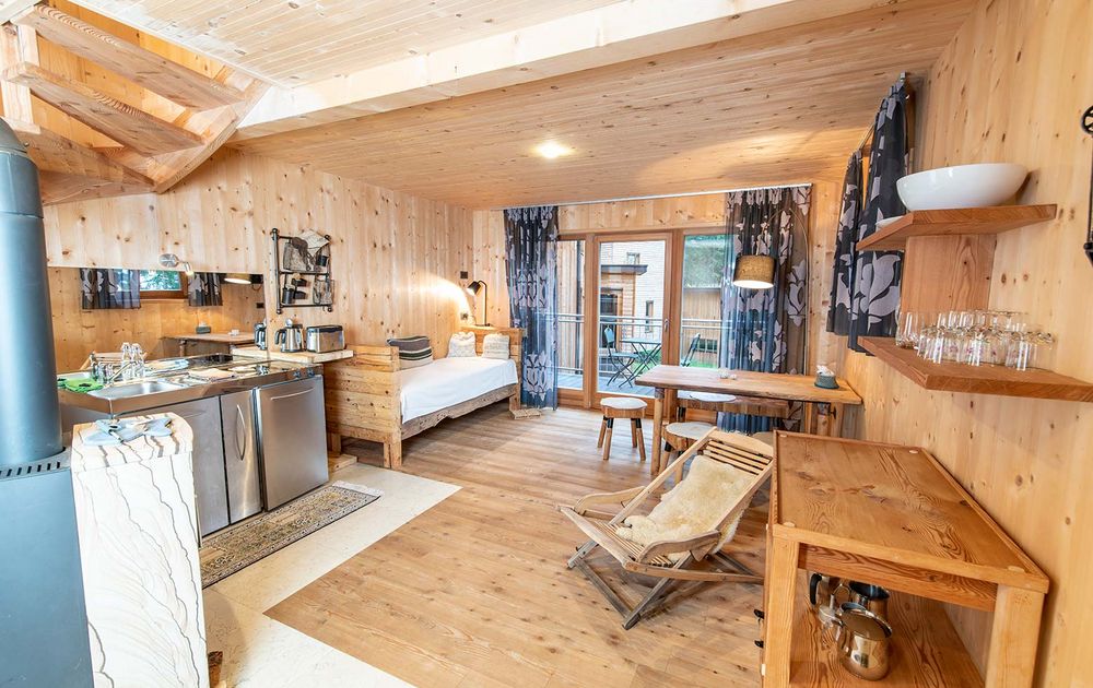 Wohnraum mit Küche, Esstisch, Couch im Chalet NONO1 feliZitas Waldchalets Urlaub Südtirol 